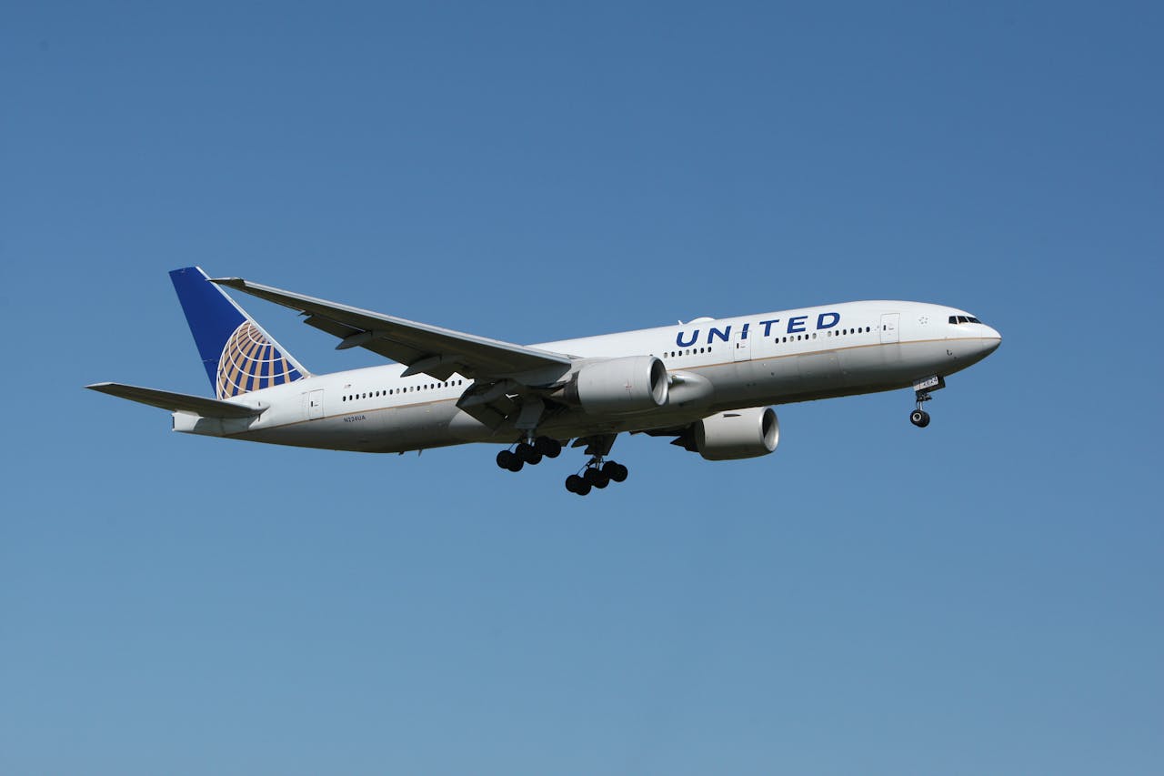 core-values A United airliner flying against a clear blue sky, showcasing air travel.